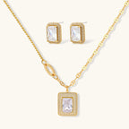 Gold-plated jewelry set with rectangular cubic zirconia stones in pave halo settings on cream background