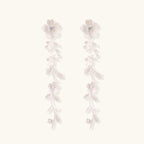 Long sterling silver drop earrings with delicate floral vine design and crystal accents on white background