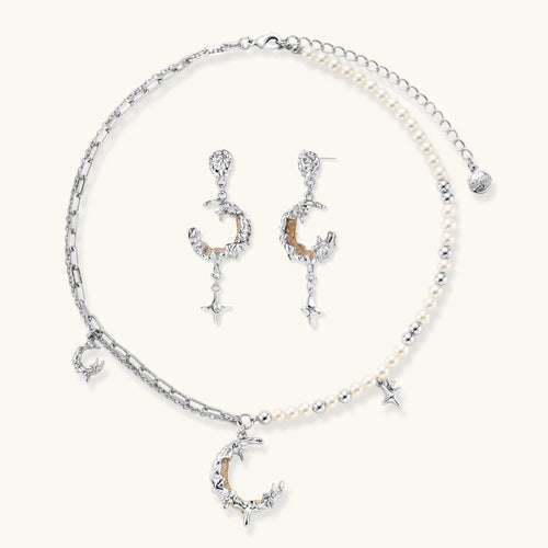 Mixed-metal jewelry set featuring layered necklaces with crescent moon pendant and pearl beads, plus matching star-drop earrings.
