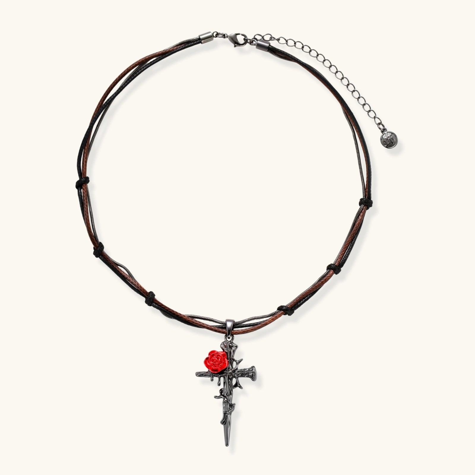Gothic cross pendant with red enamel rose and thorn details on adjustable brown cord necklace against white background.