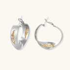 Artistic jewelry set featuring curved silver pendant with gold veining on black cord plus matching asymmetrical hoop earrings