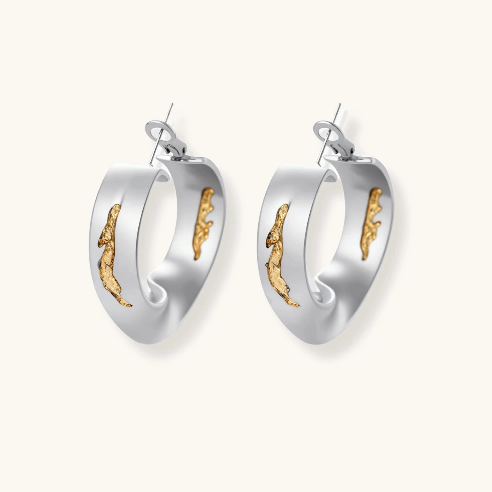 Artistic jewelry set featuring curved silver pendant with gold veining on black cord plus matching asymmetrical hoop earrings