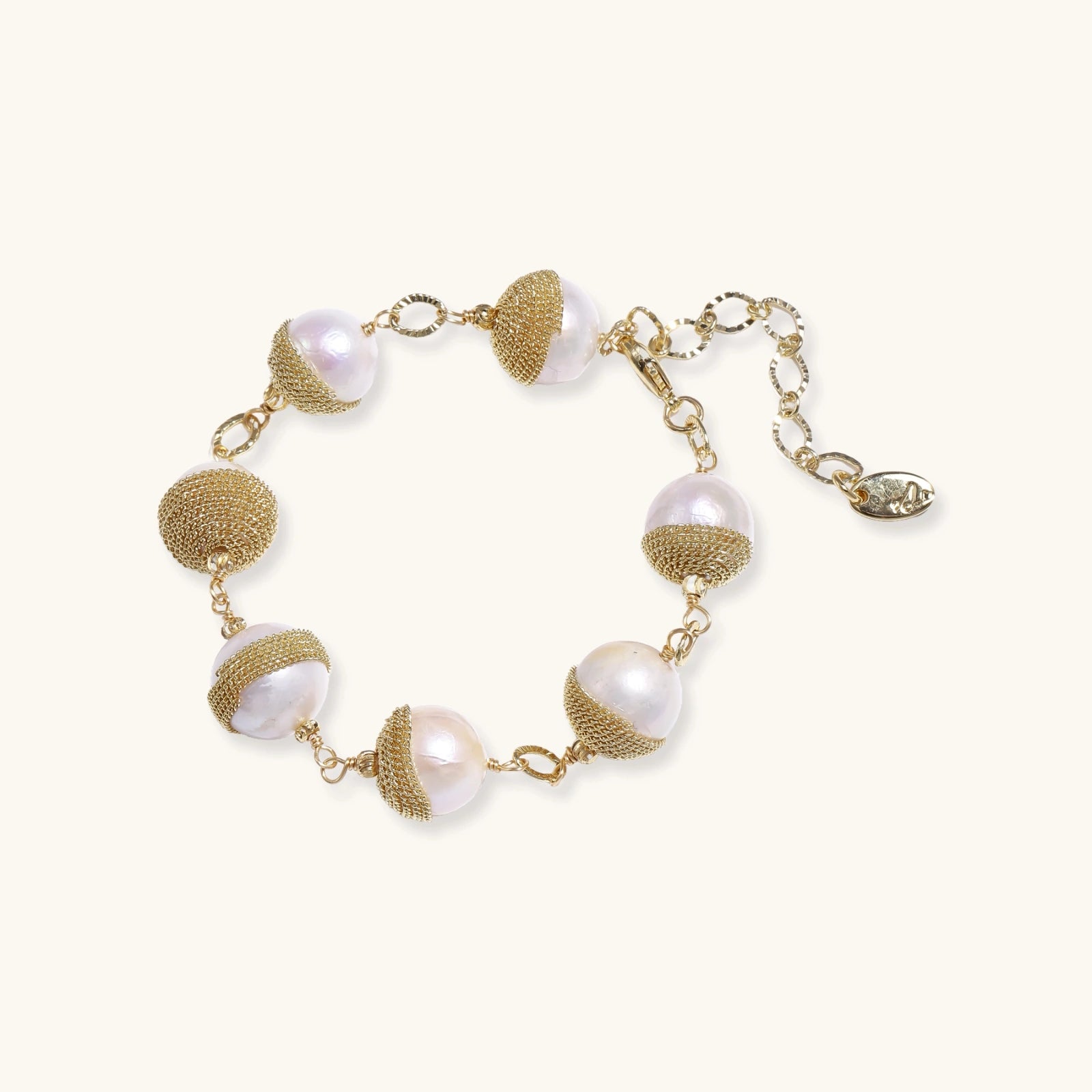 Adjustable bracelet with baroque pearls wrapped in delicate gold mesh netting connected by textured chain links