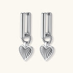 Platinum-plated 925 sterling silver rectangular hoop earrings with twisted ring connector and ribbed heart charm pendant.