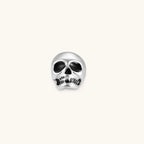 Matte silver skull stud earring with black enamel eye sockets and detailed teeth, post backing, 316L stainless steel.