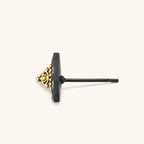 Single triangle stud earring with dark gunmetal outer frame and raised 18K gold-plated ornamental center, post back.